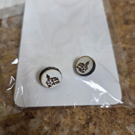 Two wooden buttons with engraved designs on a white card, placed on a marble surface.